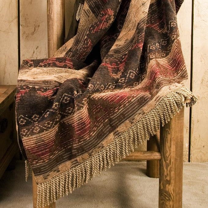 Textured blanket draped over a wooden chair with a rustic background